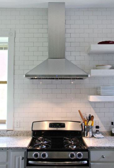 A remodeled kitchen with wall mounted chimney hood