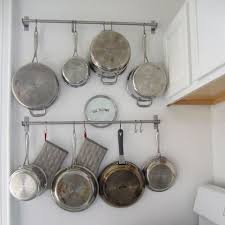 hang pots and pans on hooks to use all available space in a small kitchen